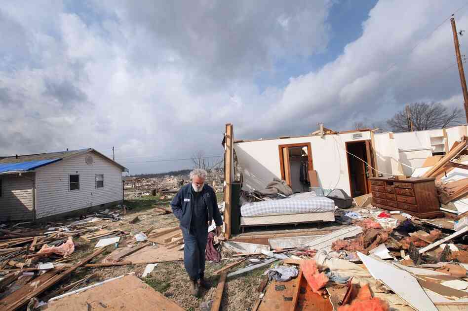 Keith Huke walks past his tornado-ravaged home in Harrisburg, Ill., on Friday. Huke escaped without any injuries. 