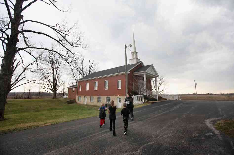 Tina Wellham takes her children to the basement of the New Bethel Baptist Church as a tornado warning sounds near Fredonia, Ky. 