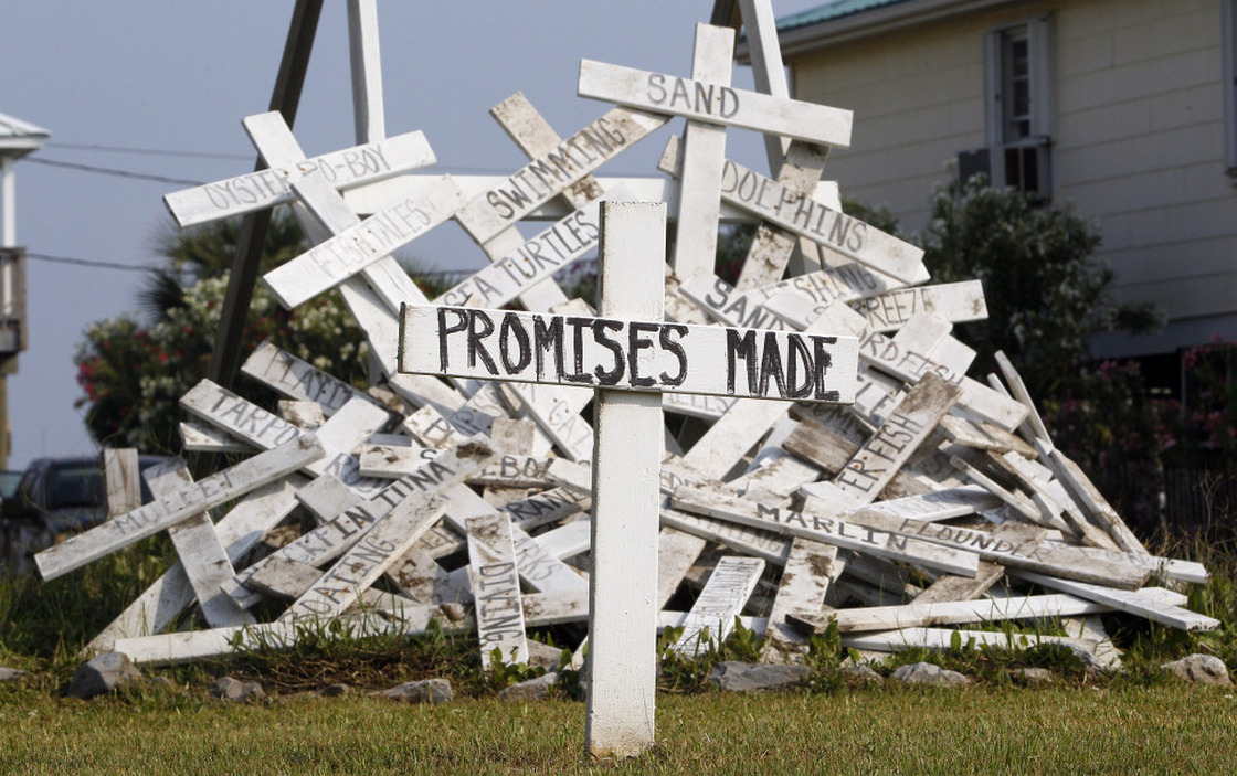  A cross with the words "Promises Made"-- referring to statements from BP and government officials — stands in front of a pile of crosses symbolizing things that were impacted by the spill, in a front yard in Grand Isle, La. 