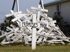 A cross with the words "Promises Made"-- referring to statements from BP and government officials — stands in front of a pile of crosses symbolizing things that were impacted by the spill, in a front yard in Grand Isle, La. A cross with the words "Promises Made"-- referring to statements from BP and government officials — stands in front of a pile of crosses symbolizing things that were impacted by the spill, in a front yard in Grand Isle, La.