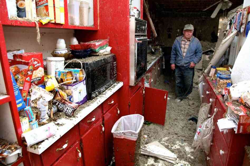 Blaine Lawson, 76, stands inside his house Friday after a reported tornado tore the roof off, in Cleveland, Tenn. Neither he nor his wife were injured. 