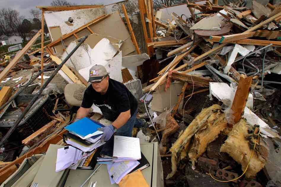 Joe Jenkins helps salvage medical records from a destroyed senior center in Harrisburg, Ill. 