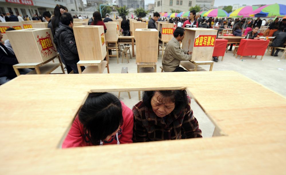 Residents of Wukan in China's southern Guangdong province fill in forms before voting in village elections on Saturday. 