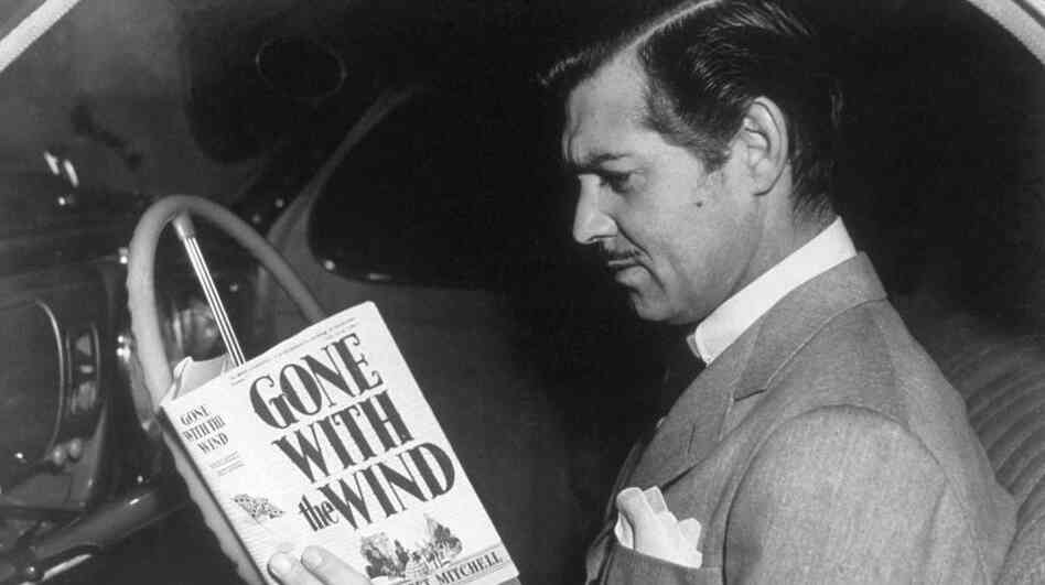 Clark Gable (as Rhett Butler) reading the novel 'Gone With the Wind' by Margaret Mitchell.