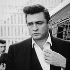 Johnny Cash walks inside the gates of Folsom Prison, preparing to perform his fourth concert for inmates there.