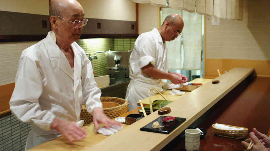 Jiro Ono (left) owns and runs a celebrated sushi restaurant in a Tokyo basement. His oldest son, Yoshikazu, waits to take over the world-famous family business. Jiro Ono (left) owns and runs a celebrated sushi restaurant in a Tokyo basement. His oldest son, Yoshikazu, waits to take over the world-famous family business.