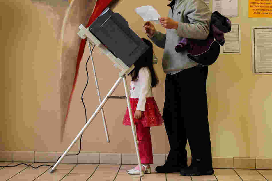 Sophia Walsh, 5, watches as her father, William Walsh, fills out his ballot in Steubenville, Ohio. 