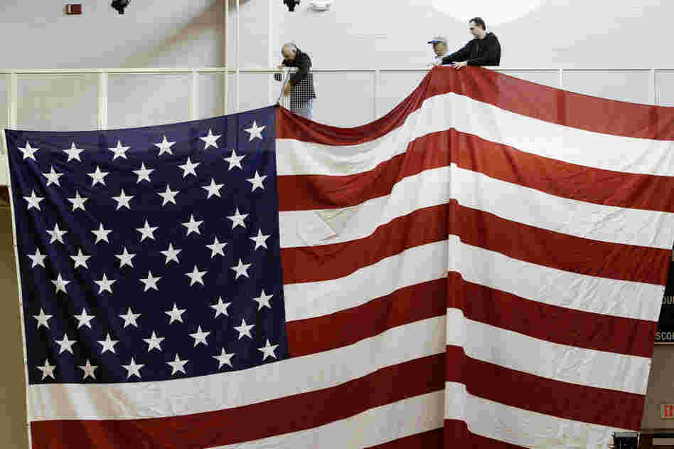 Workers hang an American flag in preparation for Santorum's election night party at Steubenville High School in Steubenville, Ohio. 