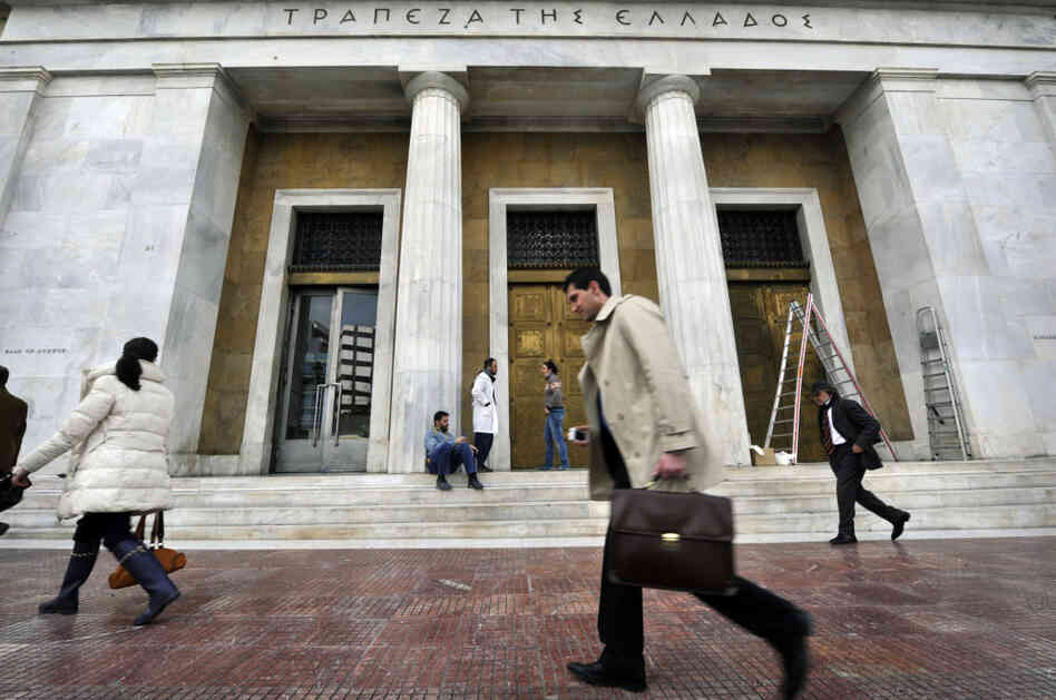 People walk past the Bank of Greece headquarters in Athens. Greece toughened its stance to push creditors to accept a debt swap and take heavy losses, just one day before the Thursday deadline for completion of the deal to avert default. People walk past the Bank of Greece headquarters in Athens. Greece toughened its stance to push creditors to accept a debt swap and take heavy losses, just one day before the Thursday deadline for completion of the deal to avert default.