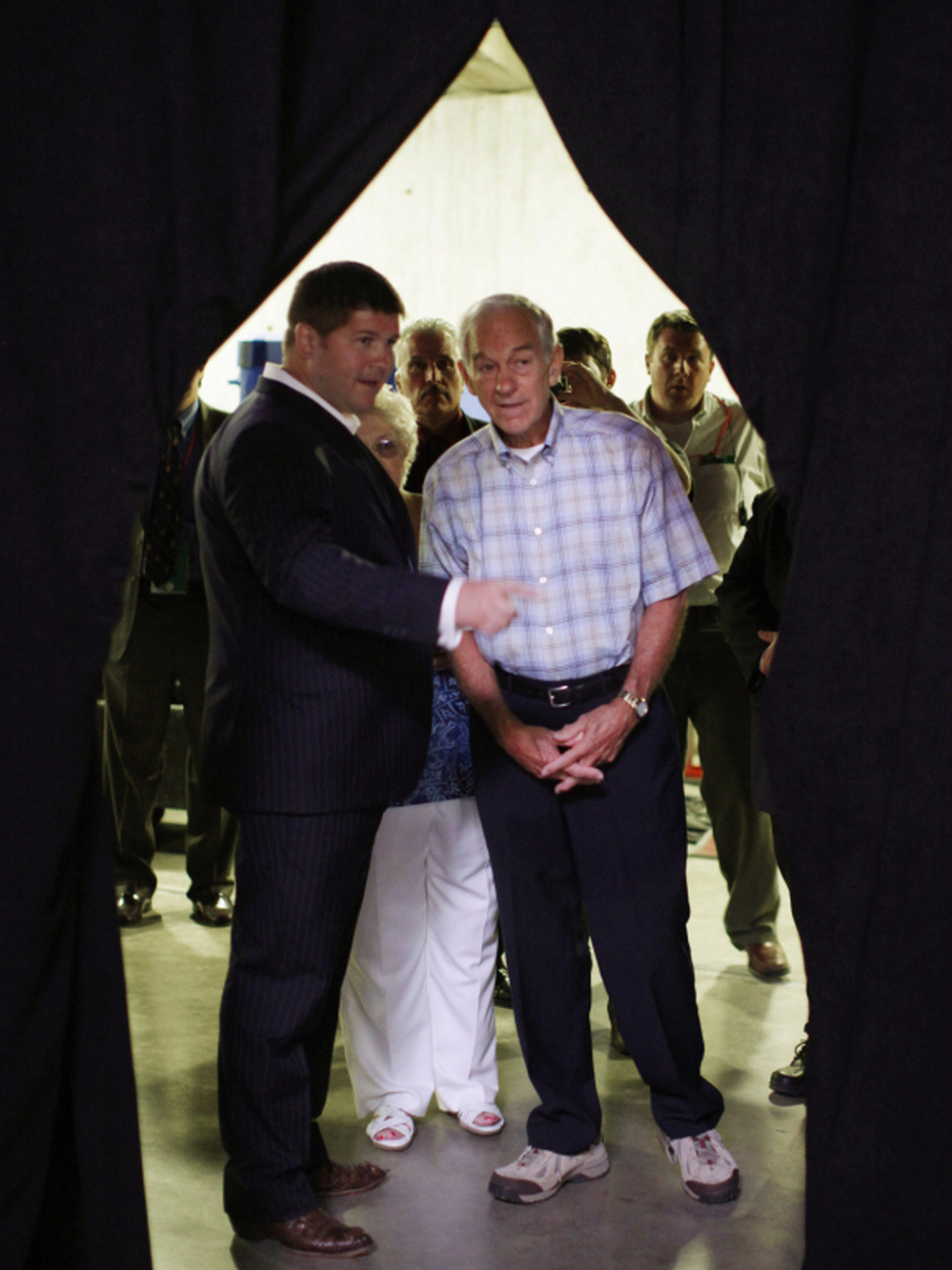 Texas Rep. Ron Paul (right) talks with the his presidential campaign manager, Jesse Benton, backstage at the Republican Party's Iowa straw poll last August.