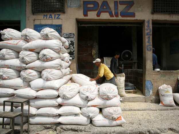 A worker piles sacks of corn at a market in Guatemala City.