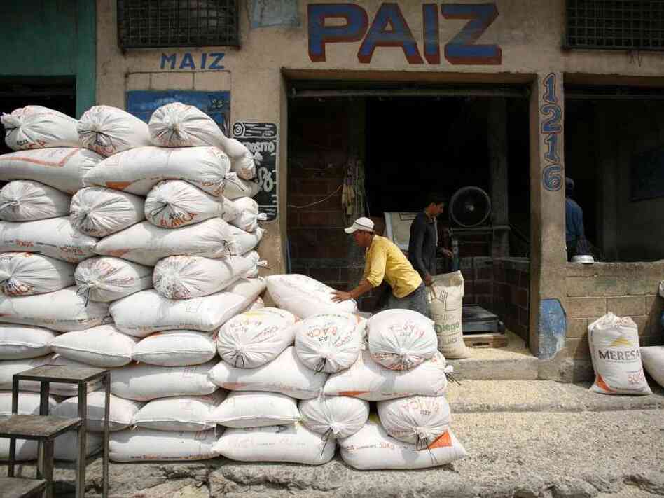 A worker piles sacks of corn at a market in Guatemala City.