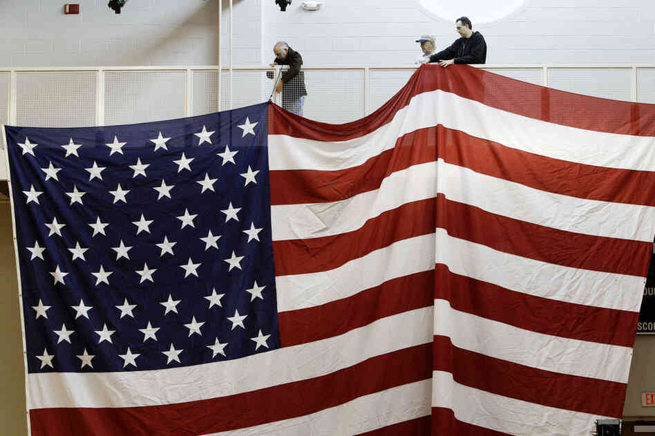 Workers hang an American flag in preparation for Santorum's election night party at Steubenville High School in Steubenville, Ohio. 