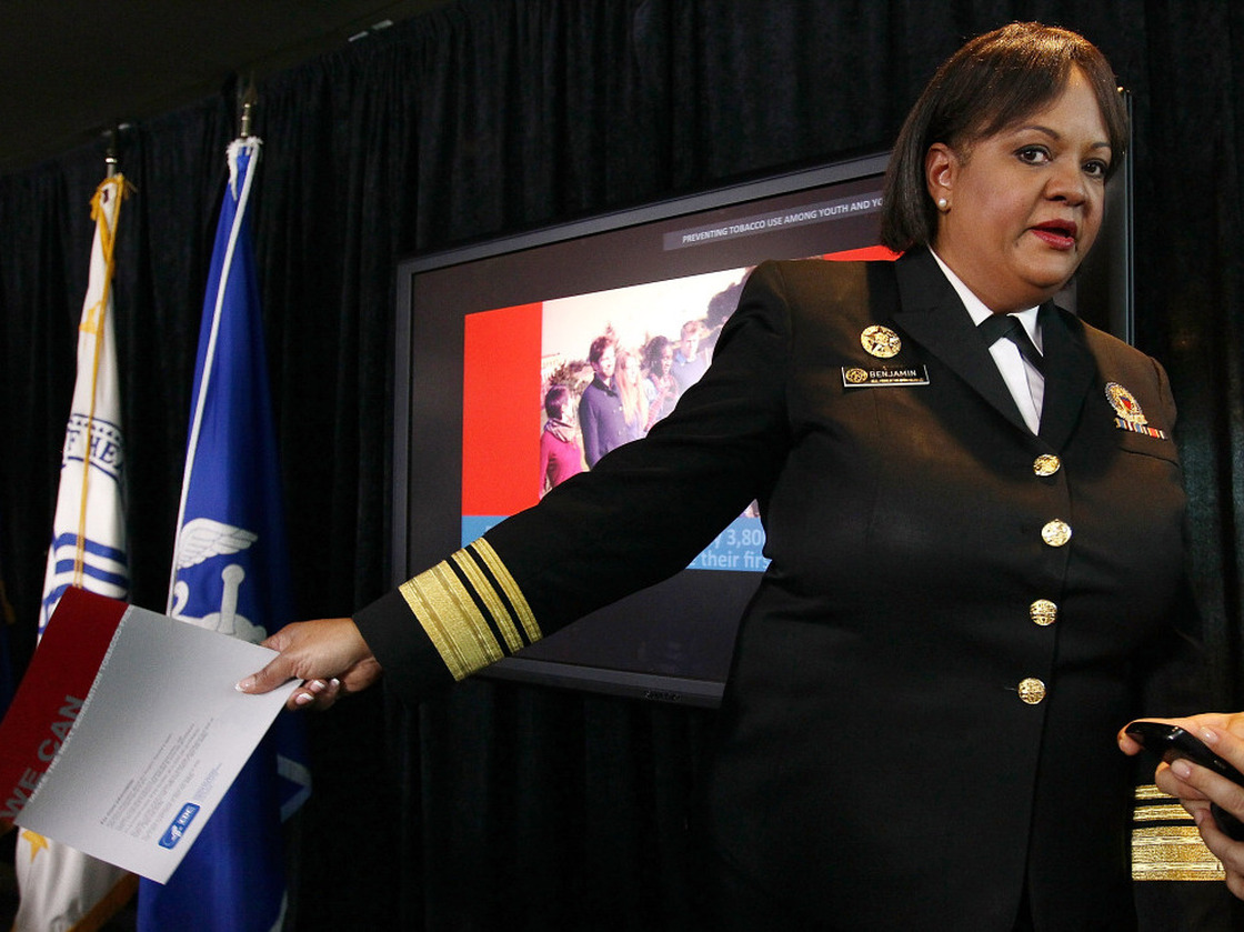U.S. Surgeon General Regina Benjamin totes a copy of a report on the need to reduce children's use of tobacco.