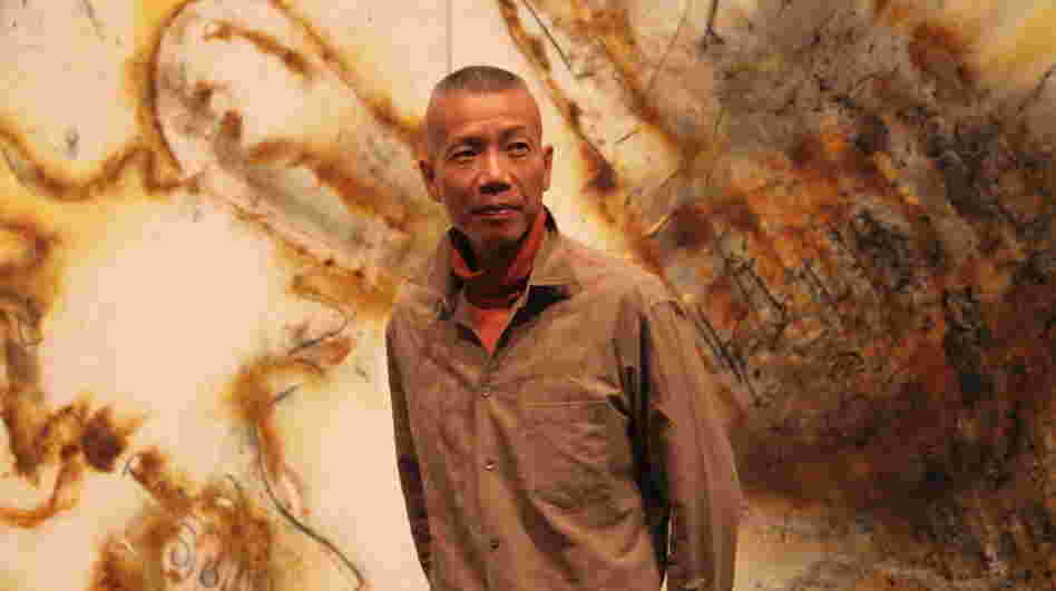 Artist Cai Guo-Qiang stands in front of a gunpowder drawing, Desire for Zero Gravity, at The Museum of Contemporary Art in Los Angeles. Cai uses a pyrotechnic process to burn shapes into large-scale canvases. Artist Cai Guo-Qiang stands in front of a gunpowder drawing, Desire for Zero Gravity, at The Museum of Contemporary Art in Los Angeles. Cai uses a pyrotechnic process to burn shapes into large-scale canvases.