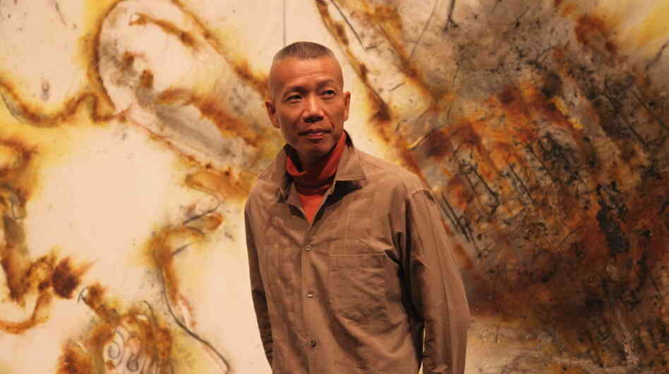 Artist Cai Guo-Qiang stands in front of a gunpowder drawing, Desire for Zero Gravity, at The Museum of Contemporary Art in Los Angeles. Cai uses a pyrotechnic process to burn shapes into large-scale canvases. Artist Cai Guo-Qiang stands in front of a gunpowder drawing, Desire for Zero Gravity, at The Museum of Contemporary Art in Los Angeles. Cai uses a pyrotechnic process to burn shapes into large-scale canvases.