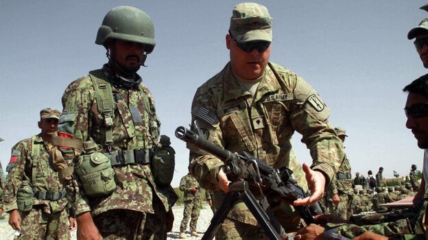 A U.S. soldier instructs Afghan soldiers in the western city of Herat last July. Afghans in security force uniforms have killed a number of U.S. and NATO troops recently. The shootings come as NATO works to prepare the Afghan forces to take control of security. 