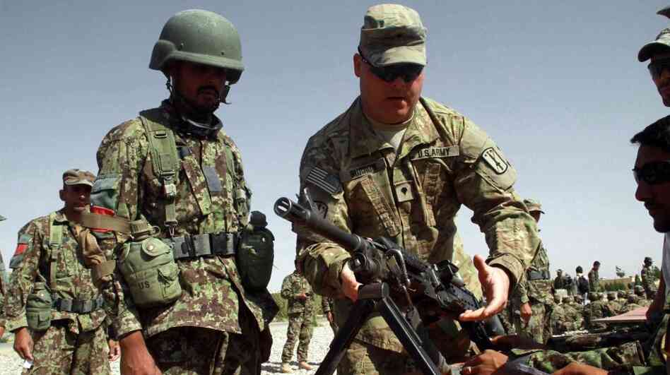 A U.S. soldier instructs Afghan soldiers in the western city of Herat last July. Afghans in security force uniforms have killed a number of U.S. and NATO troops recently. The shootings come as NATO works to prepare the Afghan forces to take control of security. 