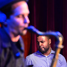 Kendrick Scott, through the crook of John Ellis' saxophone. Kendrick Scott, through the crook of John Ellis' saxophone.