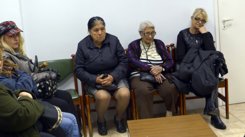 Patients sit in the waiting room of a free medical clinic in Perama, Greece, run by an international aid group, Doctors of the World, last month. Official unemployment in the port town is 80 percent, and many people are unable to afford food and medicine.