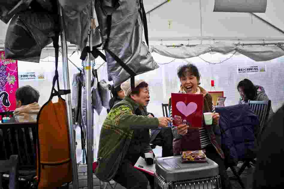 Women who lost their homes in last year's tsunami and are now living in temporary housing in Minamisanriku share a laugh.