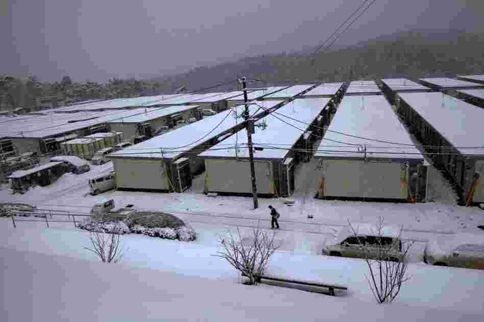 A boy walks to catch the school bus at the housing site in Minamisanriku. Thousands of people remain without homes.