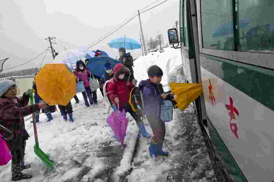 Children who are still displaced catch the bus to school.