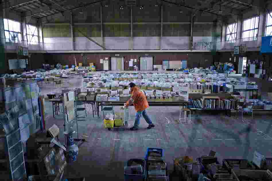 A volunteer wheels unclaimed articles inside the gym. Volunteers help clean, catalog and store the found items.