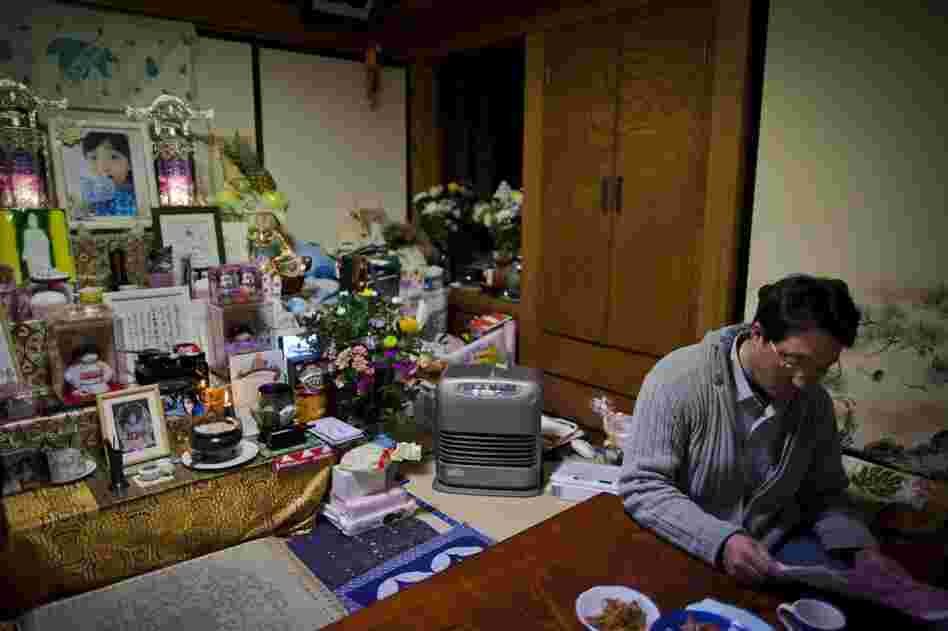 Takahiro Shito, 47, sits at home next to a Buddhist altar dedicated to his daugher, 11-year-old Chisato, who was killed during last year's tsunami at Okawa Elementary School in Ishinomaki.