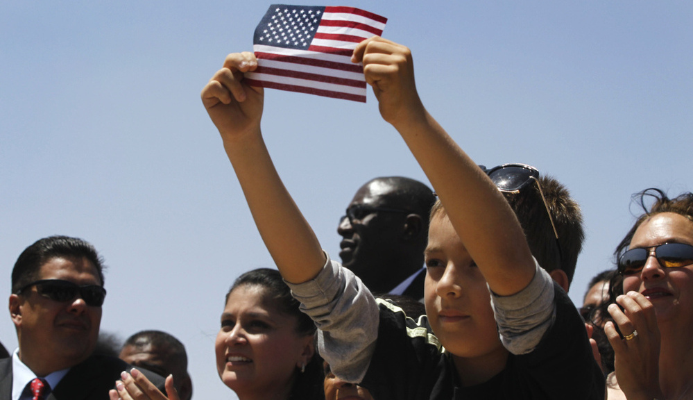 Audience members listen to President Obama talk about immigration in 2011 in El Paso, Texas. Hispanic voters face a choice this election season: continue to support Obama despite being disproportionately hurt by the economic downturn, or turn to Republicans at a time when many GOP presidential hopefuls have taken a hard line on immigration. 