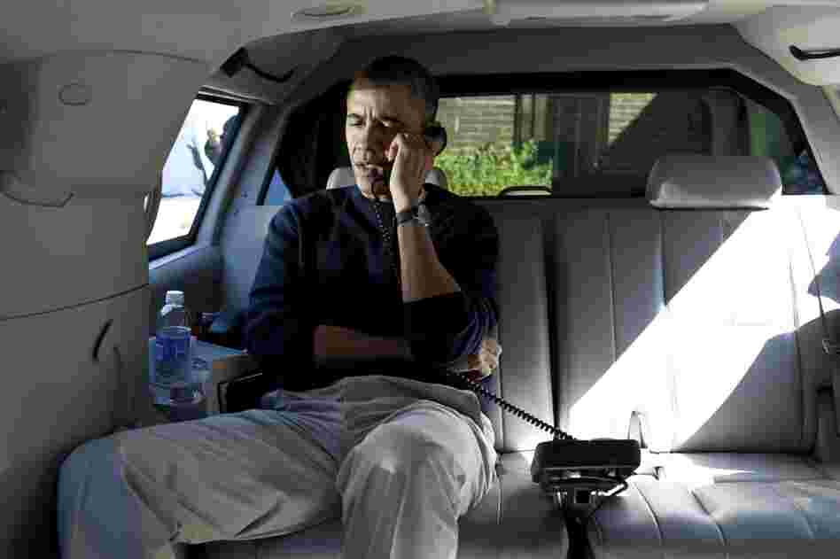 President  Obama talks on the phone with Afghanistan President Hamid Karzai from his vehicle outside a community center in Chevy Chase, Md.