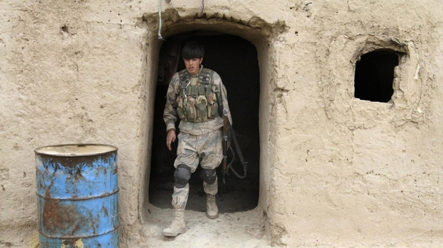 The deaths of Afghan civilians, who were allegedly shot by an American soldier, could make the U.S. mission even harder. Here, an Afghan soldier leaves a home where civilians were killed Sunday in the southern province of Kandahar. 
