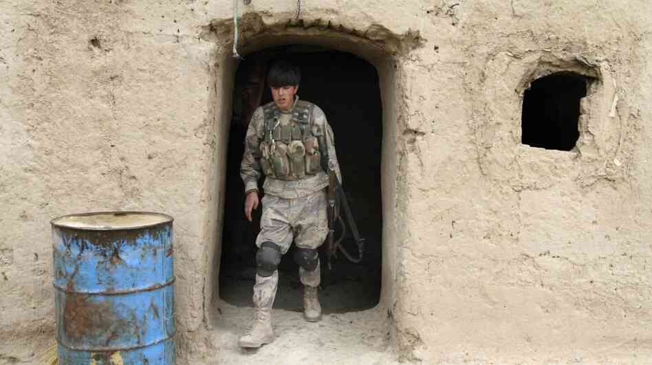 The deaths of Afghan civilians, who were allegedly shot by an American soldier, could make the U.S. mission even harder. Here, an Afghan soldier leaves a home where civilians were killed Sunday in the southern province of Kandahar. 