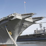 The nuclear powered aircraft carrier USS Enterprise sits at the pier as sailors move supplies and equipment in preparation for the ship's final deployment.