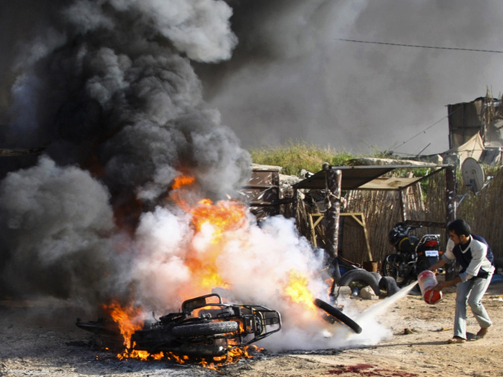 A Palestinian tries to extinguish a fire after an Israeli airstrike in Rafah in the southern Gaza Strip on Saturday. 