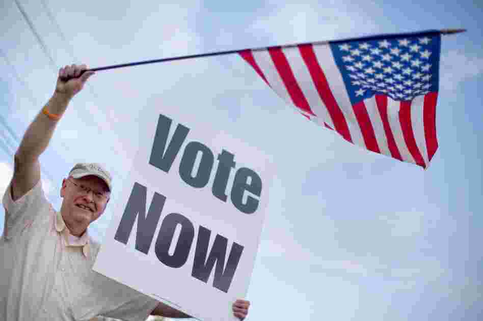 Danny Cooper of Chilton County, Ala., waves to motorists outside a polling place. 