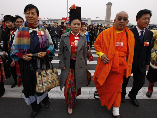 Delegates wear the traditional garb of their ethnic minority — the Burberry bag at left (estimated cost: $800) notwithstanding — in Beijing on March 3.