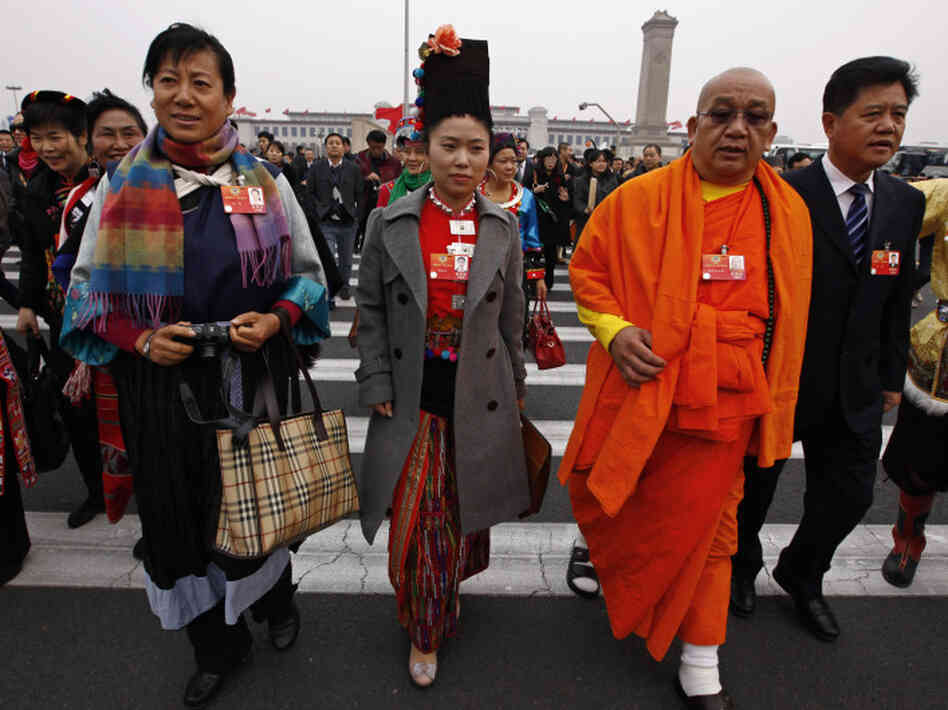 Delegates wear the traditional garb of their ethnic minority — the Burberry bag at left (estimated cost: $800) notwithstanding — in Beijing on March 3.