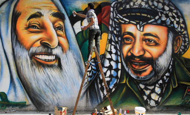 Palestinian artist Mohammed al-Dairi paints a mural of late Palestinian leader Yasser Arafat (right) and late Hamas leader Sheikh Ahmed Yassin (left), in Gaza City. Hamas leaders are divided on what direction to take the Islamist movement, with some calling for reconciliation with Arafat's Fatah movement.