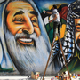 Palestinian artist Mohammed al-Dairi paints a mural of late Palestinian leader Yasser Arafat (right) and late Hamas leader Sheikh Ahmed Yassin (left), in Gaza City. Hamas leaders are divided on what direction to take the Islamist movement, with some calling for reconciliation with Arafat's Fatah movement.
