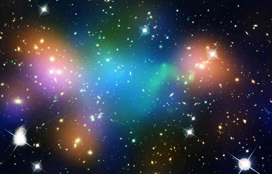  This image of the galaxy cluster Abell 520 — 2.4 billion light-years away — may challenge some of our basic theories about Dark Matter. It is overlaid with false-color maps showing concentrations of starlight (orange), hot gas (green) and mass (blue). The mass is mostly Dark Matter.