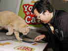 In this photograph taken by AP images for Friskies, Ben Huh, of I Can Haz Cheezburger, challenges topcat gamer Buddy to a match of Friskies "You vs. Cat" during the SXSW Interactive Festival on Sunday, Mar. 11, 2012.