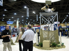 A vendor talks to attendees at the Border Security Expo in Phoenix, Ariz., next to a display of sophisticated cameras and sensors painted to blend into the desert. A vendor talks to attendees at the Border Security Expo in Phoenix, Ariz., next to a display of sophisticated cameras and sensors painted to blend into the desert.