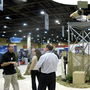 A vendor talks to attendees at the  Border Security Expo in Phoenix, Ariz., next to a display of sophisticated cameras and sensors painted to blend into the desert.