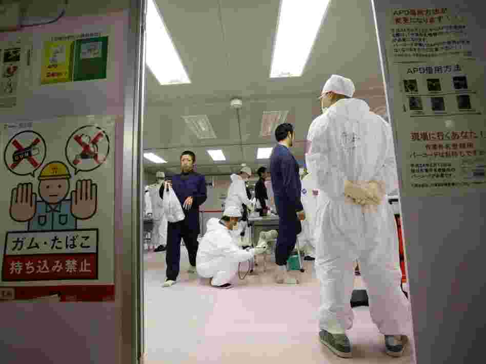Workers are given radiation screenings as they enter the emergency operation center at Tokyo Electric Power Co.'s Fukushima Dai-Ichi nuclear power plant.