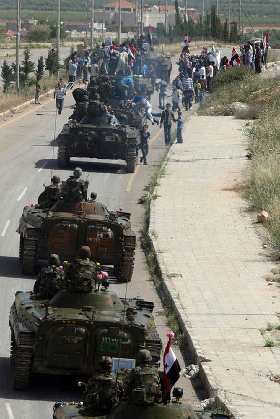 Syrian army troops drive out of the southern city of Daraa on May 5, following a crackdown on protests. 