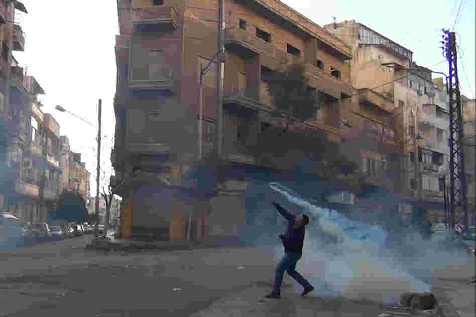 The Syrian uprising began a year ago. Here, a protester in Homs throws a tear gas canister back at security forces on Dec. 27, 2011. 