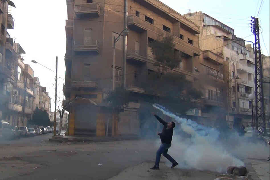 The Syrian uprising began a year ago. Here, a protester in Homs throws a tear gas canister back at security forces on Dec. 27, 2011. 