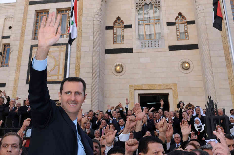 President Assad waves to supporters after a speech at the parliament in Damascus on March 30. 