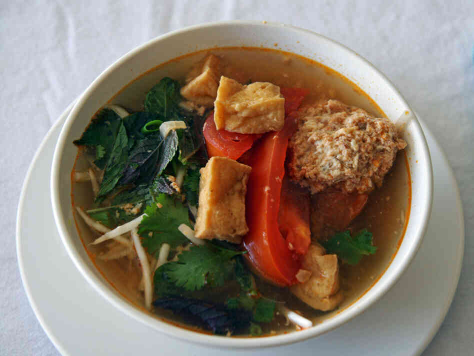 Linh Nguyen's Vietnamese soup features fried tofu, tomatoes, a scattering of fresh herbs and some delicate poached crab and pork dumplings.